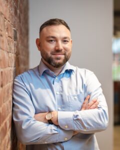 Konrad Szatkowski, Head of Growth at IVF Media, is smiling in a professional portrait photo, wearing a light blue shirt.